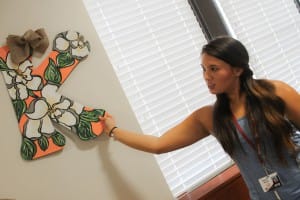 Kasey Kimery of Pearl, a sophomore studying dental hygiene at Hinds Community College, hangs wall decorations in her room in Allen-Dukes-Whitaker Residence Hall on the Raymond Campus on Monday, Aug. 3. Kimery, a captain in the Hi-Steppers, was among students moving in early to participate in band camp.
