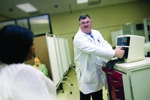 Dr. Carl Mangum, an instructor at the University of Mississippi Medical Center School of Nursing, demonstrates a piece of machinery in the school's learning lab. (April Garon/Hinds Community College)