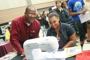 Curtis Gore, instructor at the Utica Campus, gives Tyran Crain, a Puckett eighth-grader, a quick lesson on using a Brother computerized sewing machine. She was among more than 1,200 area students who visited the Hinds Community College Career Exploration Day on Nov. 8.