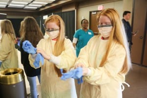 Florence twins Gabby Bradford, left, and Abby Bradford, eighth-graders, learned how to put on surgical gear with the help of Baptist Health Systems nurse Rebekah Peacock, not pictured. Baptist Health Systems, one of the three sponsors of Hinds Community College’s Career Exploration Day on Nov. 8 at the Rankin Campus. The other two sponsors were Empire Trucking and Stribling Equipment.