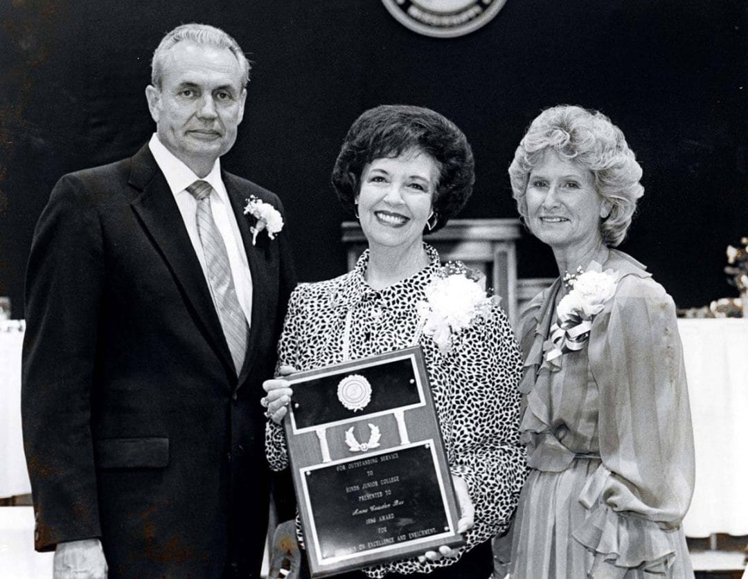 Dr. and Mrs. Muse standing with Mrs. Bee holding an award