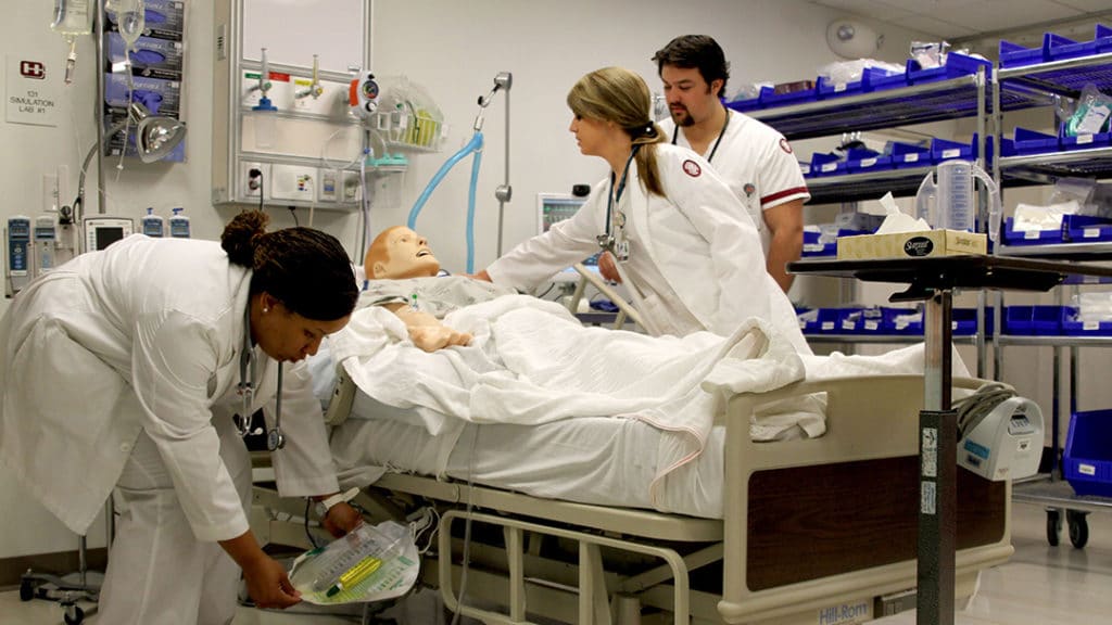 three nursing students attending a simulated patient