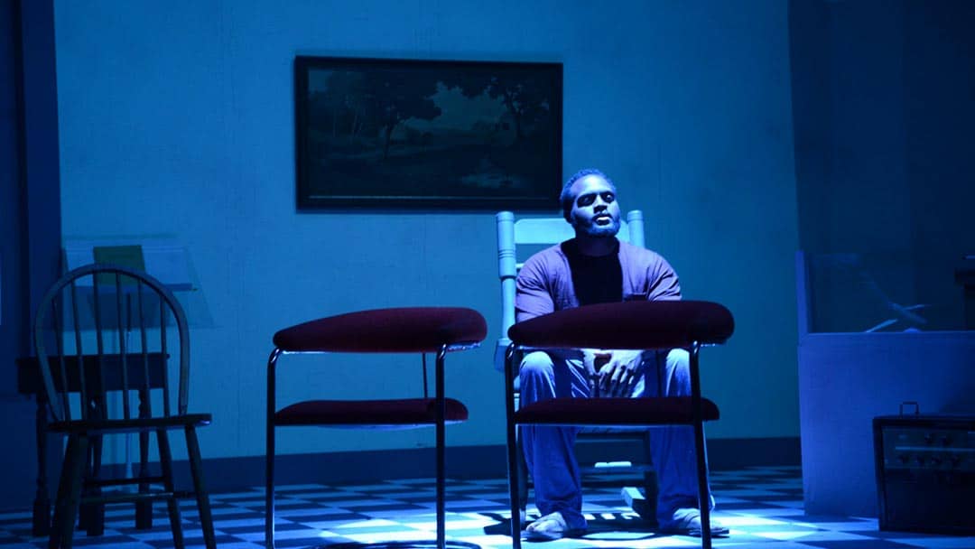 actor on stage in blue light
