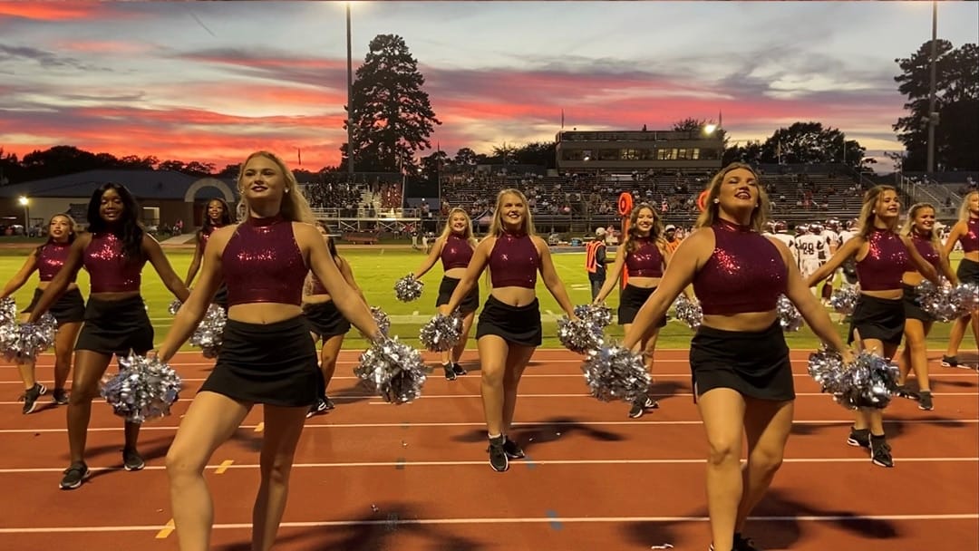 college female dance team on the sideline of a football game dancing for the crowd